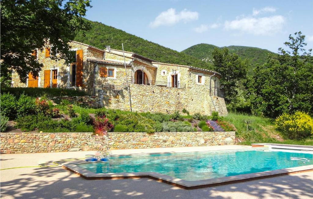 a house with a swimming pool in front of a building at Amazing Home In Dieulefit With Outdoor Swimming Pool, Wifi And 1 Bedrooms in Dieulefit