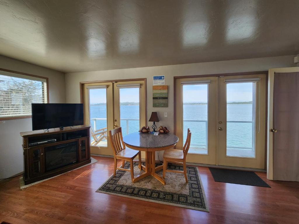 a living room with a table and chairs and a television at Plainview Motel in Coos Bay