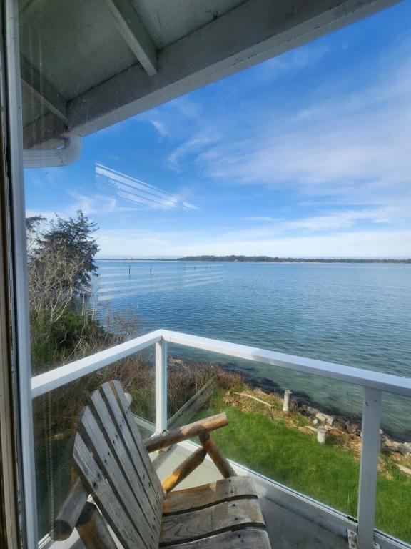 a porch with a chair and a view of the water at Plainview Motel in Coos Bay