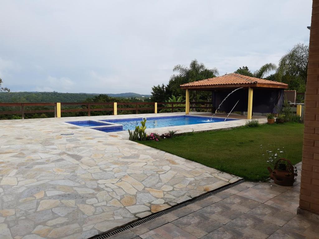 a backyard with a swimming pool and a gazebo at Chácara Paiva in Jarinu