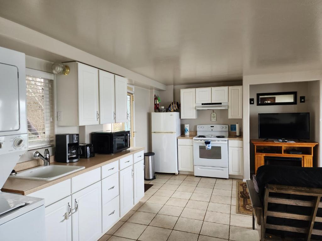 a kitchen with white cabinets and white appliances at Plainview Motel in Coos Bay