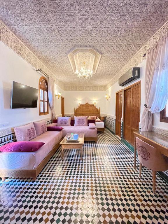 a living room with a couch and a table at Le Grand Alcazar - Riad in Fès