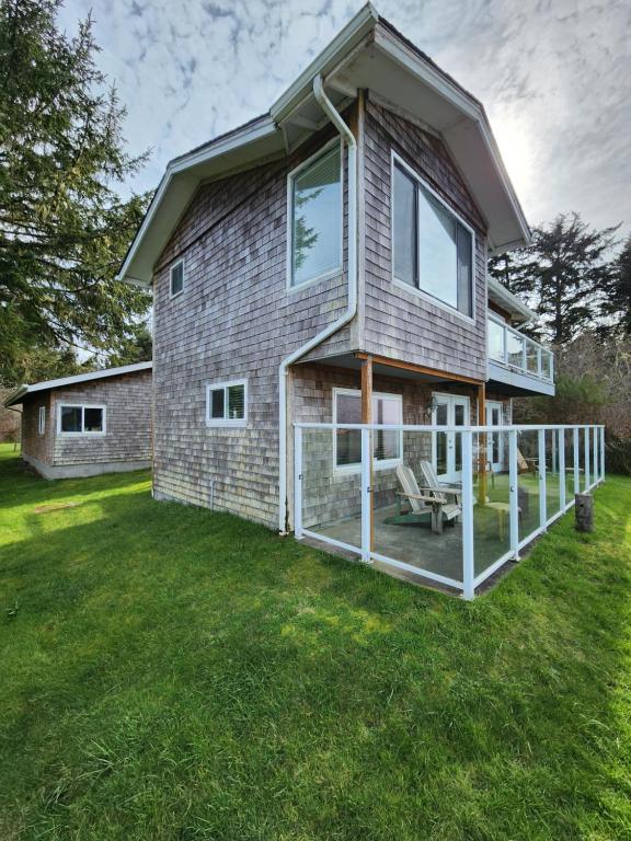 a house with a porch and a lawn at Plainview Motel in Coos Bay