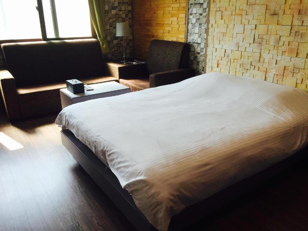 a bedroom with a large bed and a couch at Pearl Business Hotel in Gumi