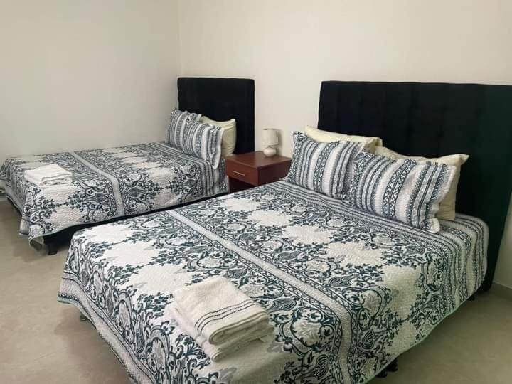 a bedroom with two beds and a table with a night stand at LODGE ELIZABETH HOUSE in San Francisco