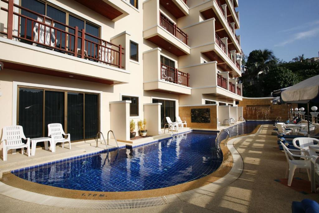 a hotel swimming pool in front of a building at Jiraporn Hill Resort in Patong Beach