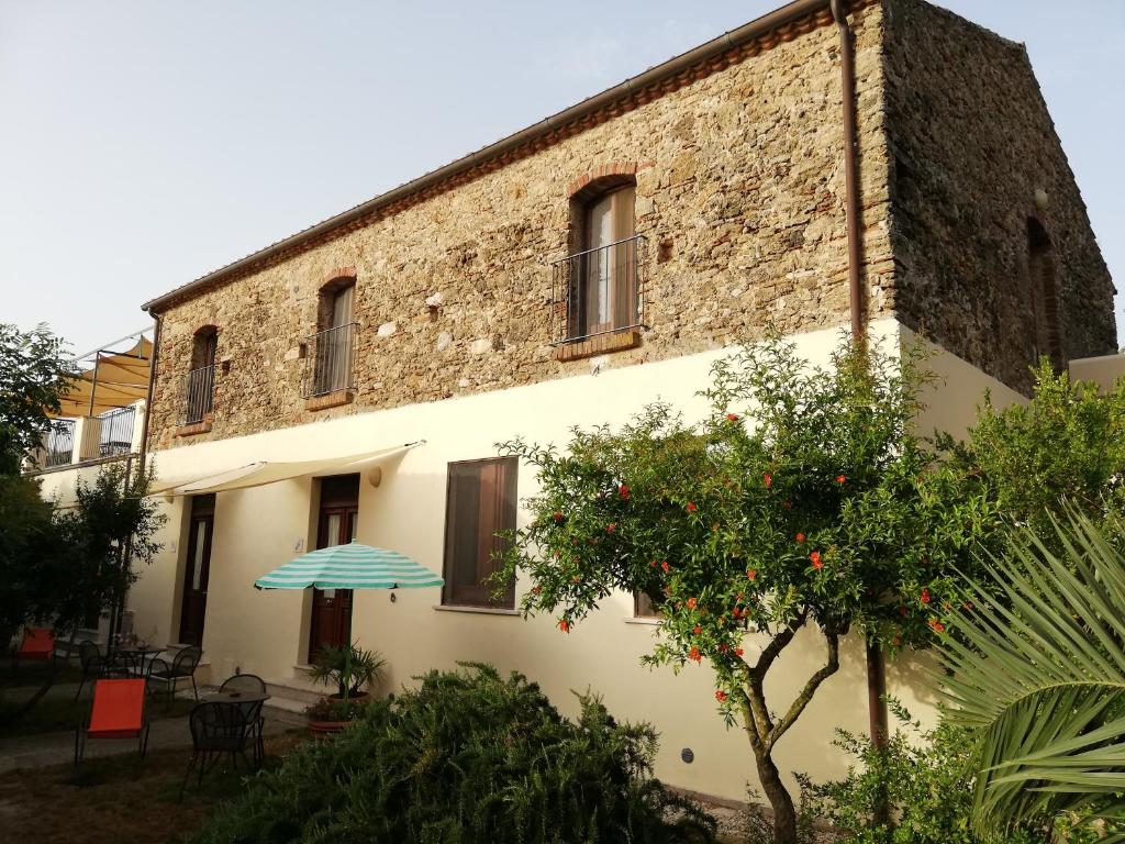 un edificio con un ombrello davanti di Casa del Geco a Paestum