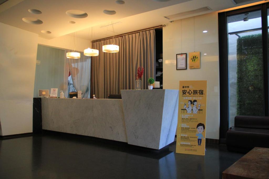 a lobby with a reception desk with a sign at The Galerie Hotel in Taichung