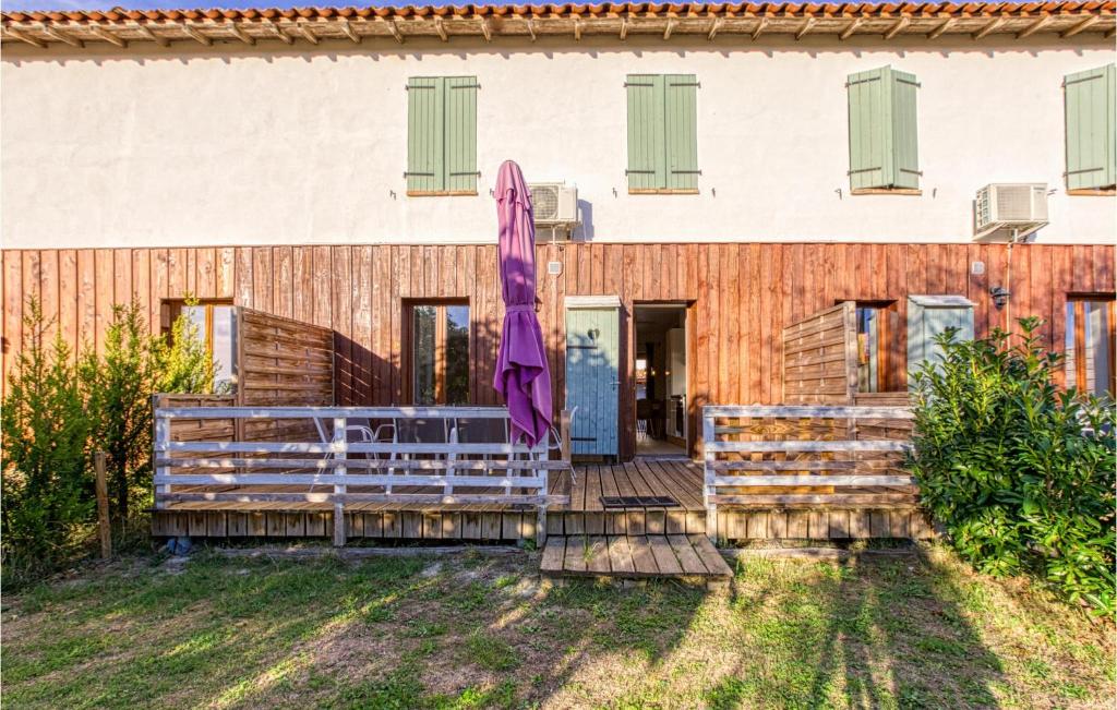 uma casa com um guarda-chuva roxo em frente em Cozy Home In Rabastens With Outdoor Swimming Pool em Rabastens