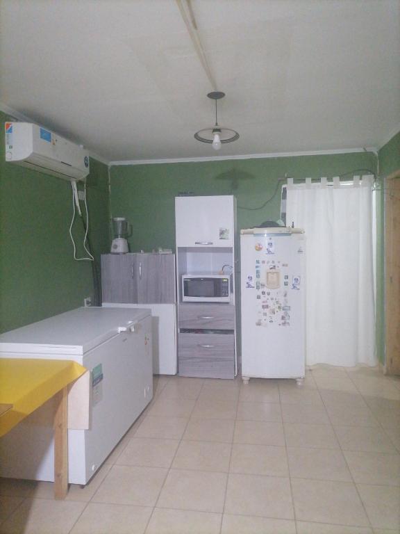 a kitchen with green walls and a white refrigerator at Casa Juliana in El Aibal