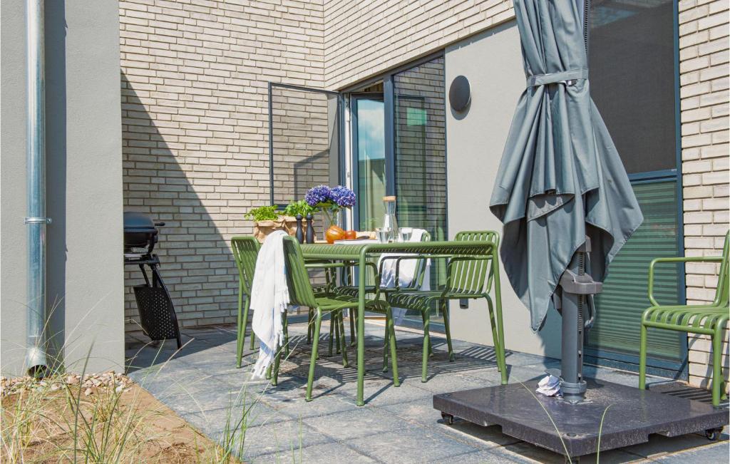 einen Tisch und Stühle mit Sonnenschirm auf einer Terrasse in der Unterkunft 2 Bedroom Lovely Home In Lembruch-dmmer See in Lembruch
