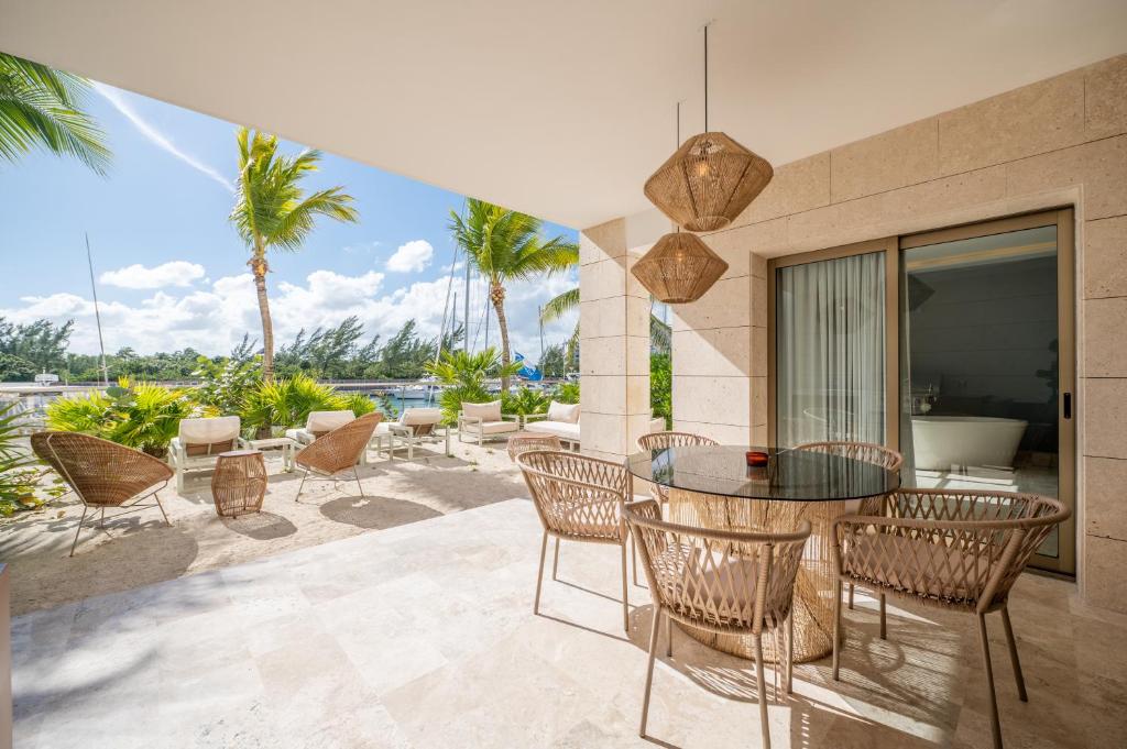un patio con tavolo, sedie e palme di La Amada Cancun a Cancún