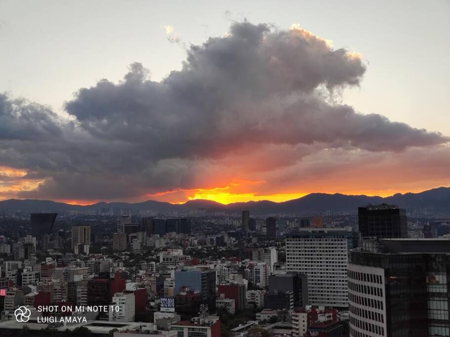 a view of a city with a sunset in the background at Amazing views Hi-Rise, HS Wi-Fi, pool, jacuzzi, paddle, in Mexico City