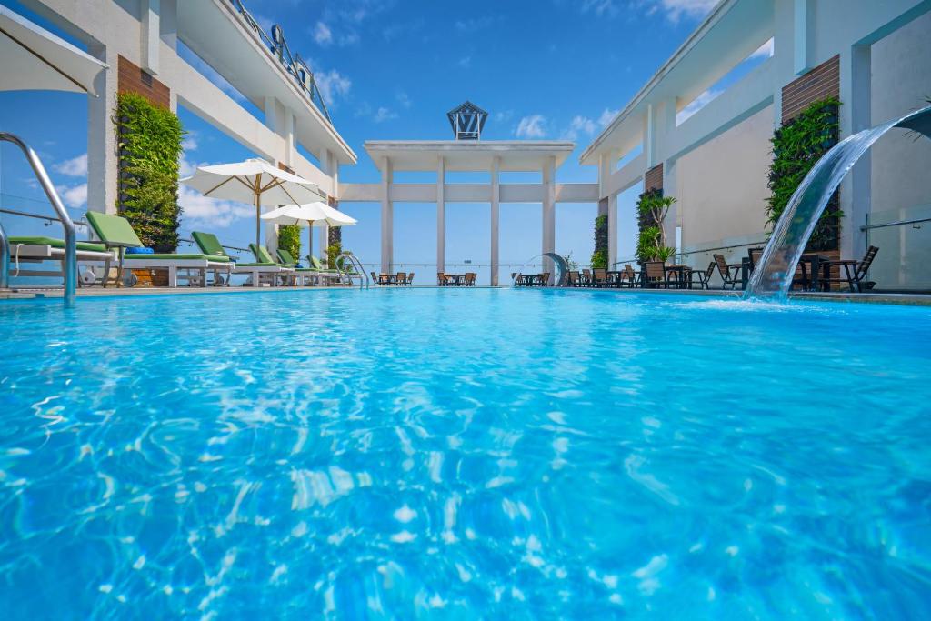 a pool at a hotel with chairs and a swimming pool at Diamond Sea Hotel in Danang