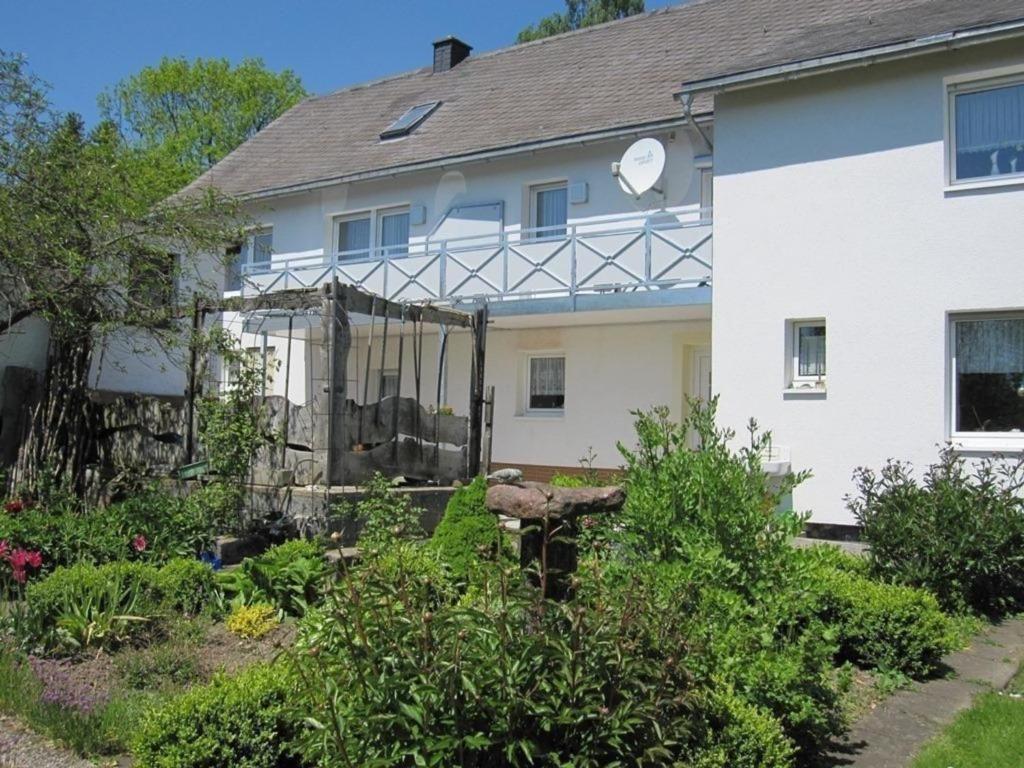 dom z ogrodem przed nim w obiekcie Komfortable Ferienwohnung mit Balkon und Blick ins Grüne in der Nähe von Willingen und Winterberg w mieście Medebach