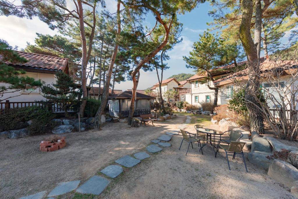 um quintal com uma mesa e cadeiras e uma casa em Clear morning pet friendly pension em Gyeongju