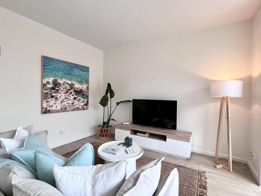 un soggiorno con divano e TV di Modern Beach Oasis in Elwood Village a Melbourne