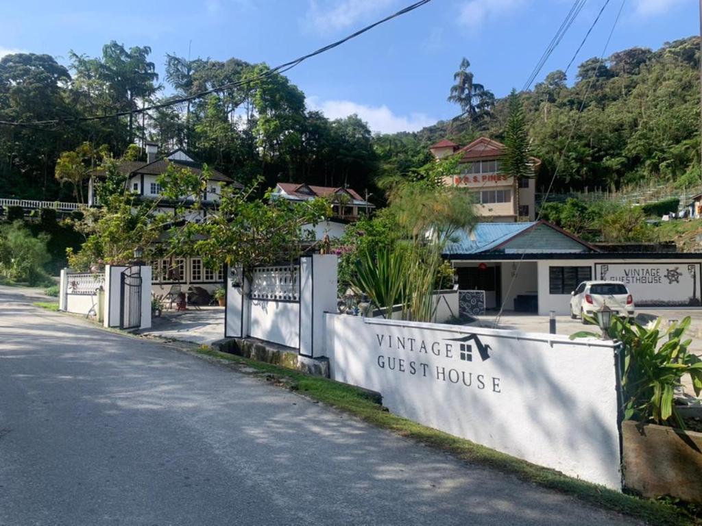 a sign for a villager guest house on the side of a road at Vintage Guesthouse in Tanah Rata