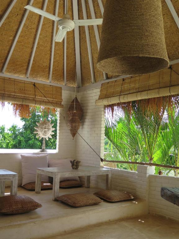 a living room with a table and some windows at Sal Secret Spot in Uluwatu