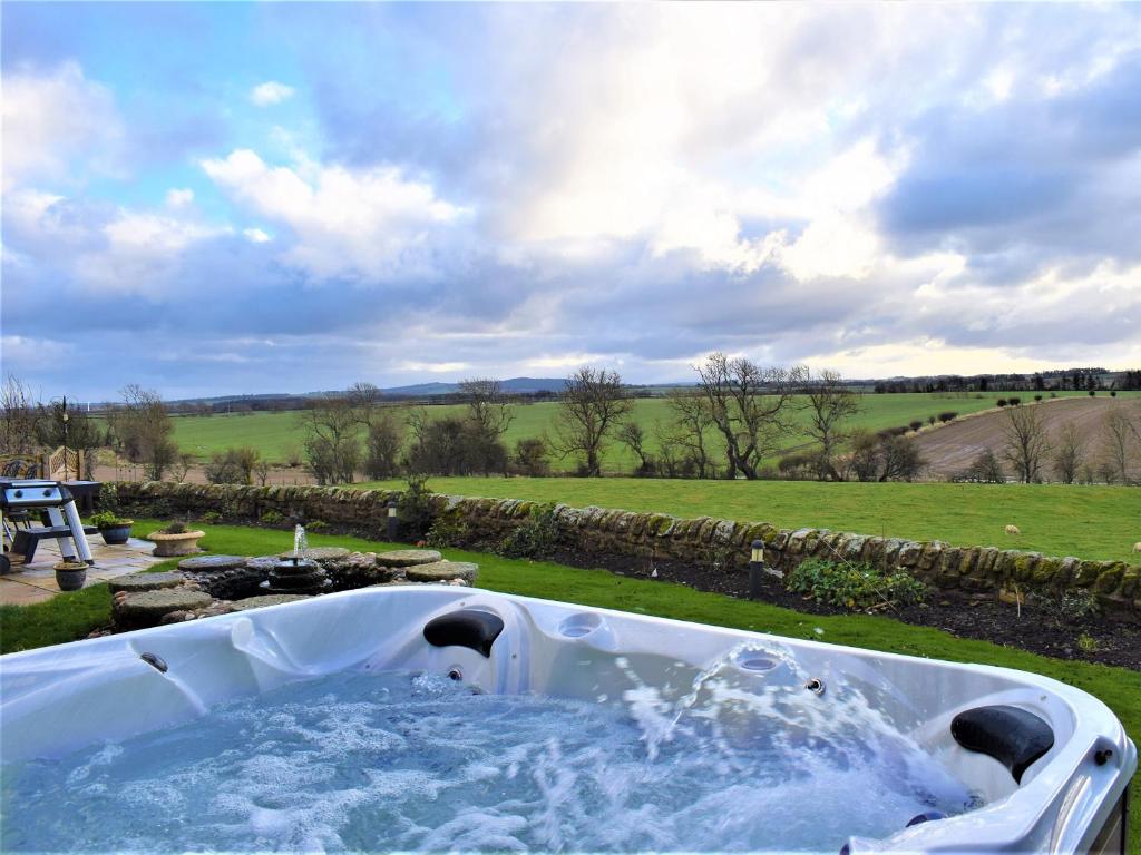 a bath tub filled with water in a yard at The Old Farmhouse in Ancroft