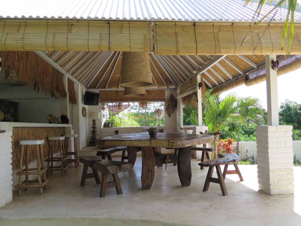 a wooden table and chairs under a wooden pergola at Sal Secret Spot in Uluwatu