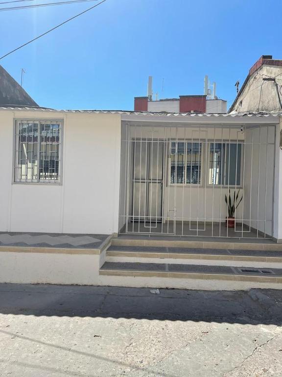 un bâtiment blanc avec une porte à l'avant dans l'établissement Apartamento Vacacional Riohacha, à Ríohacha