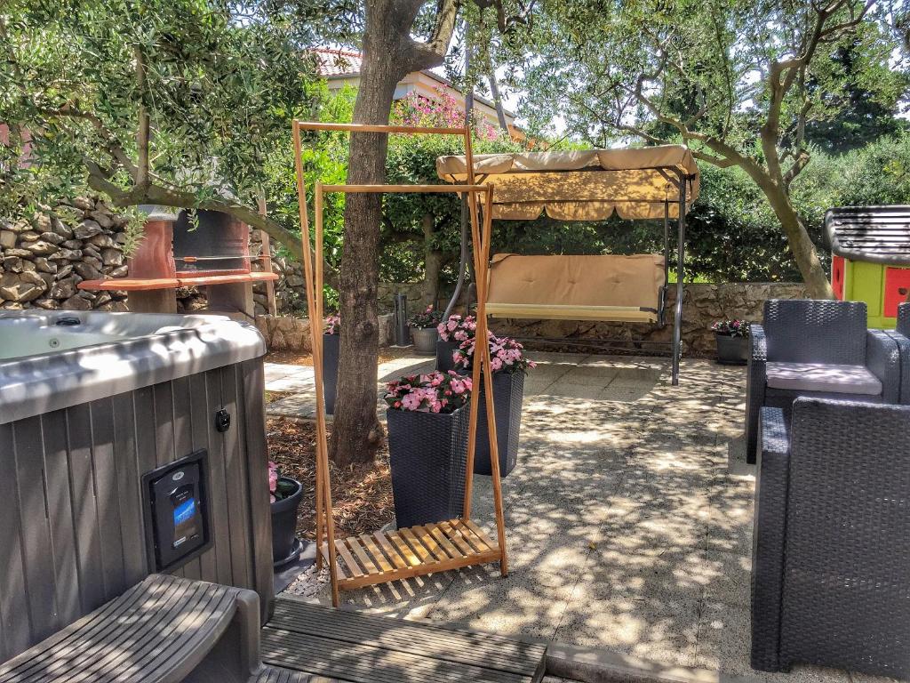 een tuin met een prieel met bloemen erin bij Apartment Ivana with jacuzzi in Vir