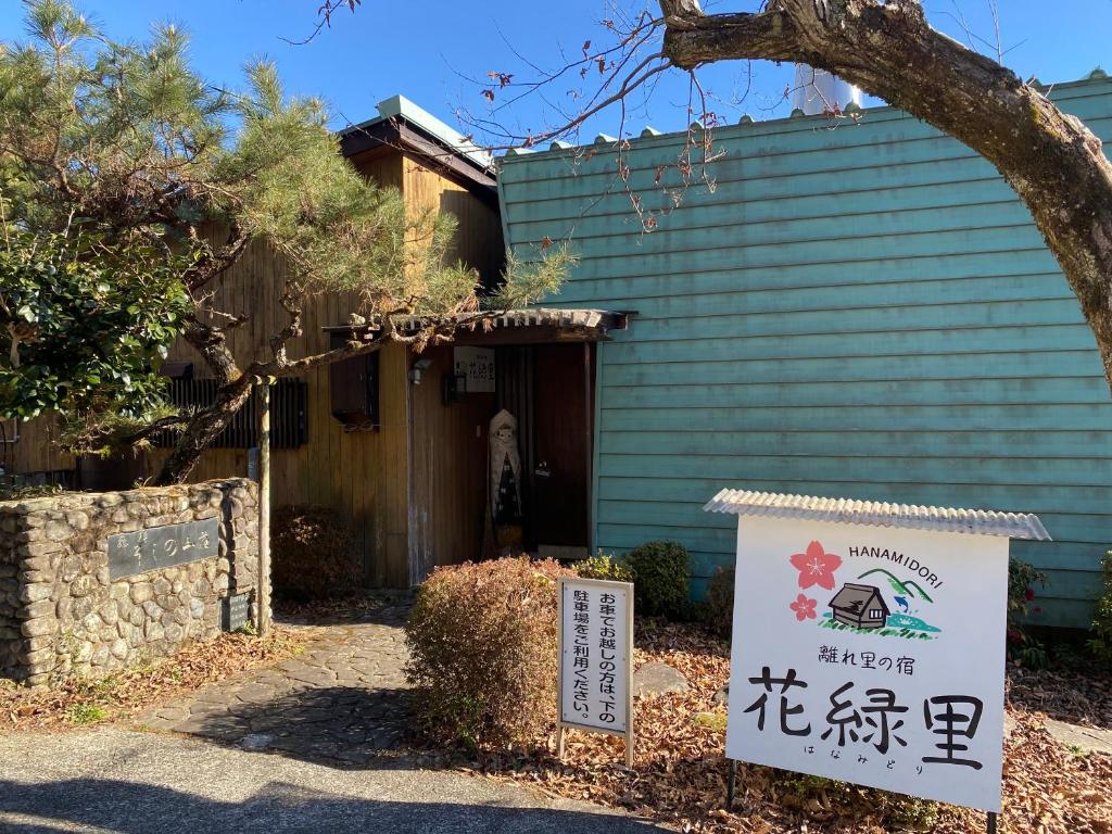 a building with a sign in front of it at 花緑里-Hanamidori-そしの山荘 岐阜下呂金山郡上貸切ロッジ高原リゾート in Gujo