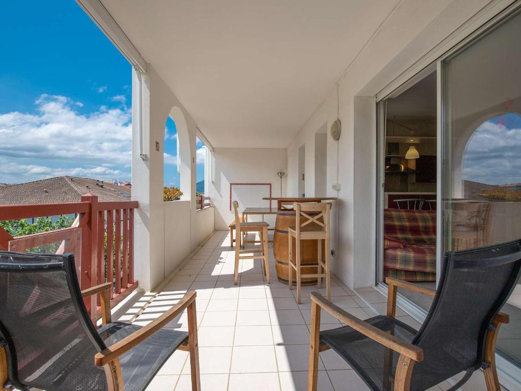 un balcon avec deux chaises et une table dans l'établissement Spacieux appartement 3 chambres avec terrasse, à deux pas des commerces et proche plage à Hendaye - FR-1-2-416, à Hendaye