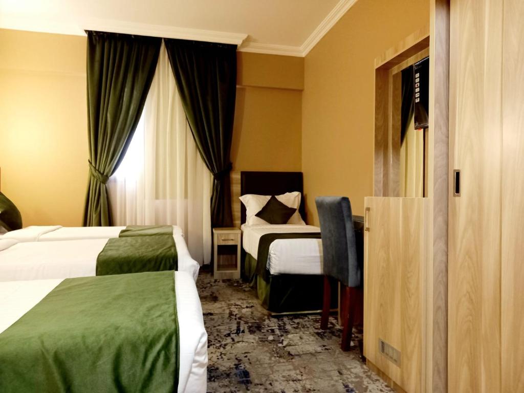 Hayah Diamond Hotel في المدينة المنورة: غرفة فندقية بسريرين ومكتب