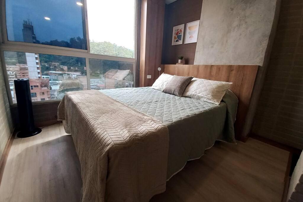 1 dormitorio con cama y ventana grande en 701 Loft amazing view, en Medellín