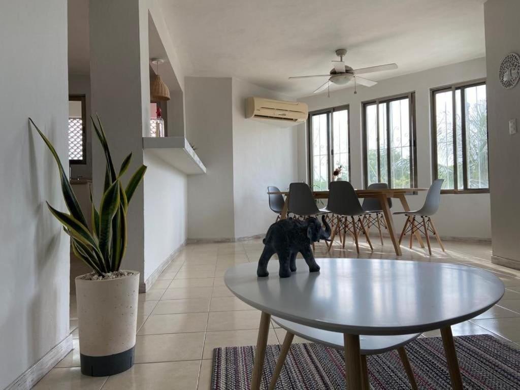 坎昆的住宿－Hermoso condominio recién remodelado con alberca y super ubicación，坐在客厅桌子上的一只黑狗