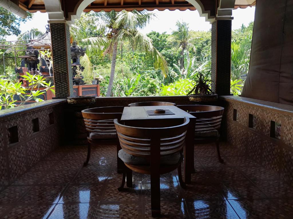 パダンバイにあるHarmony House Stayの椅子とテーブル、窓のあるレストラン