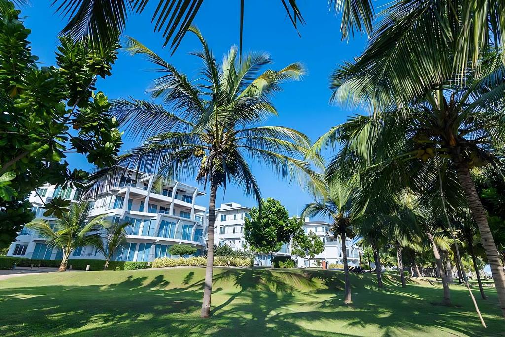 a building with palm trees in front of it at Beach Paradise Nilaveli in Trincomalee