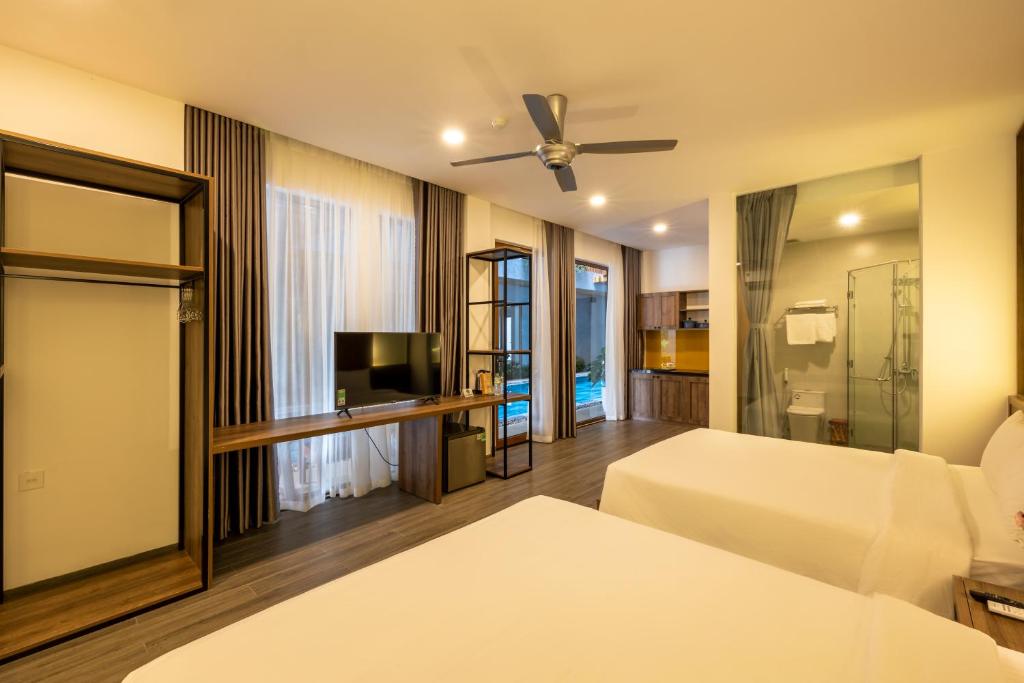 a hotel room with two beds and a television at Moon Sun Boutique Villa Hotel in Hue