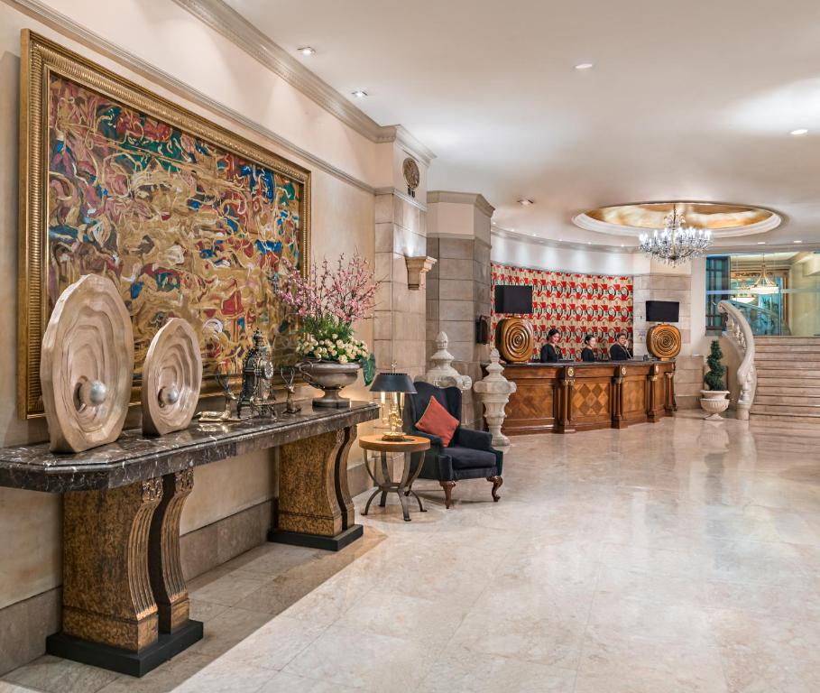 a lobby with a large painting on the wall at Makati Palace Hotel in Manila