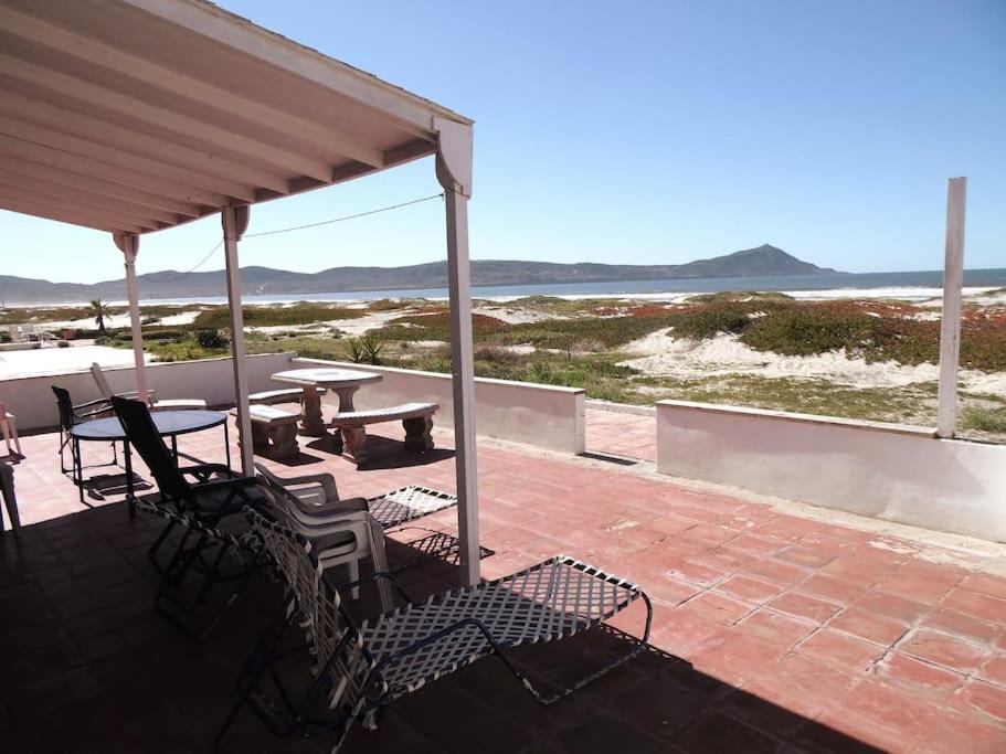 un patio con mesa de picnic y sillas y la playa en Casa Blanca frente a la playa, en Playa del Estero