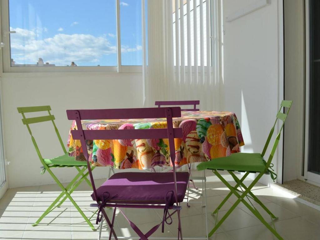 une table et deux chaises dans une pièce avec une table et une nappe dans l'établissement Appartement climatisé 3 pièces, 6 couchages, proche plage et centre, garage inclus - FR-1-250-61, au Grau-du-Roi