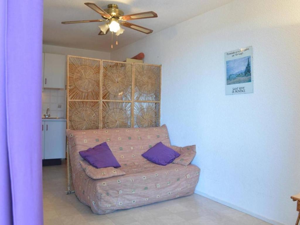un salon avec un canapé et un ventilateur de plafond dans l'établissement Appartement climatisé 2 pièces, 4 couchages, proche Seaquarium avec parking au Grau-du-Roi - FR-1-250-74, au Grau-du-Roi