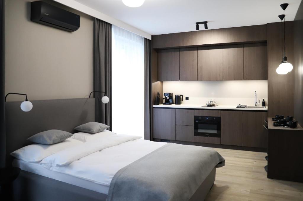 sypialnia z dużym łóżkiem i kuchnią w obiekcie Apartamenty Legionów 40A - A27 w Kaliszu