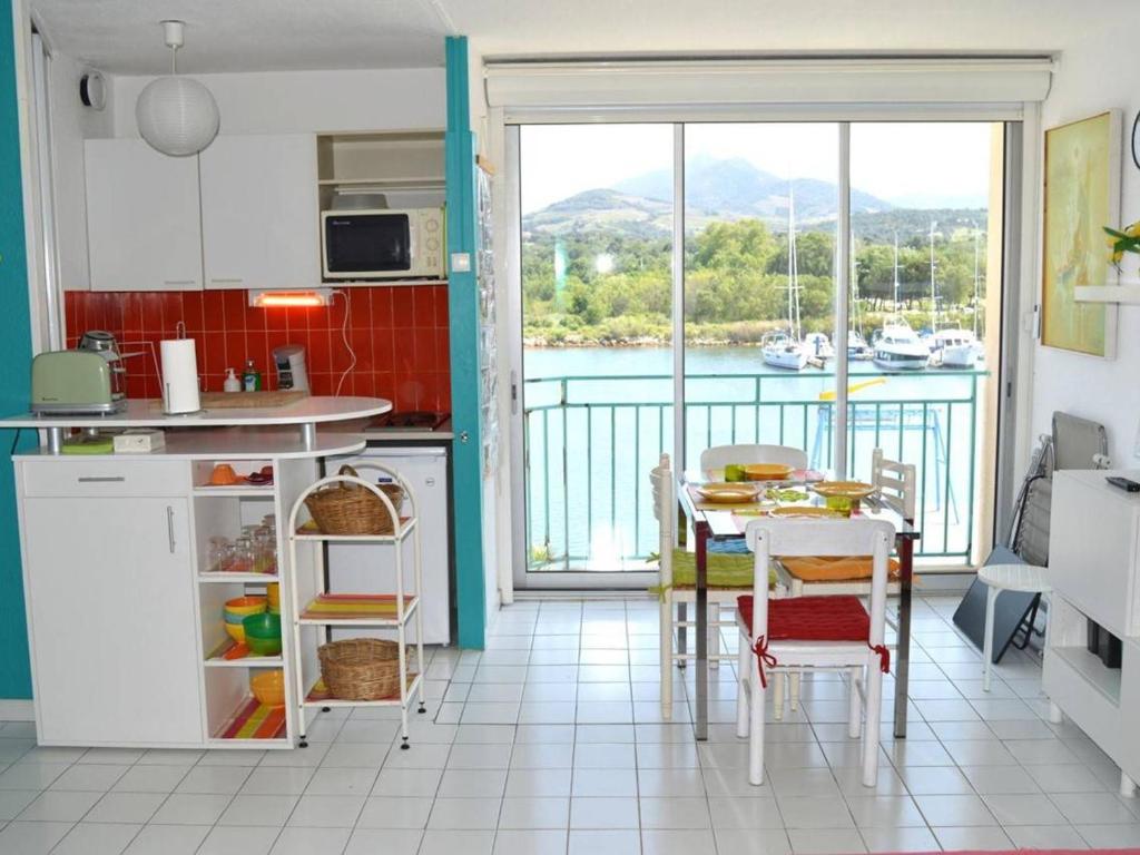 - une cuisine avec une table et une vue sur l'eau dans l'établissement Appart 2 pièces, climatisé, 150m de la mer, garage - Argelès-sur-Mer - FR-1-225-579, à Argelès-sur-Mer