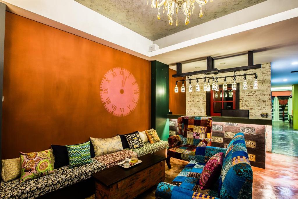 a living room with a couch and a clock on the wall at Arch Inn in Hualien City