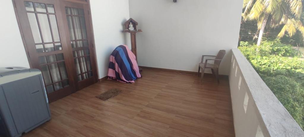 Cette chambre dispose d'un couloir avec des portes et de parquet. dans l'établissement Thalpitiya villa, à Wadduwa
