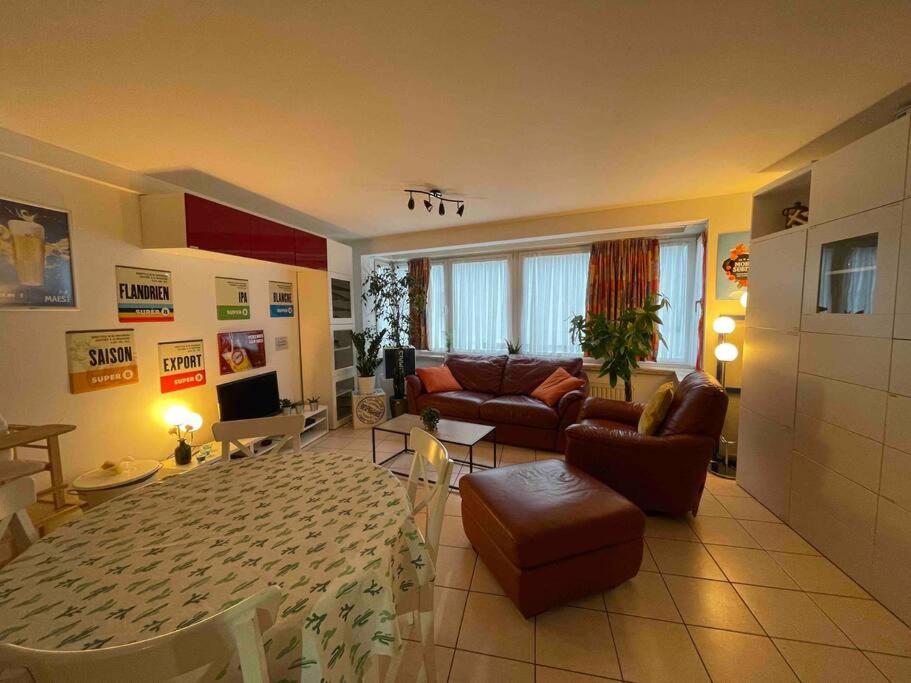 een woonkamer met een bank en een tafel bij Appartement 90m2 op 70m van het strand. in Oostende