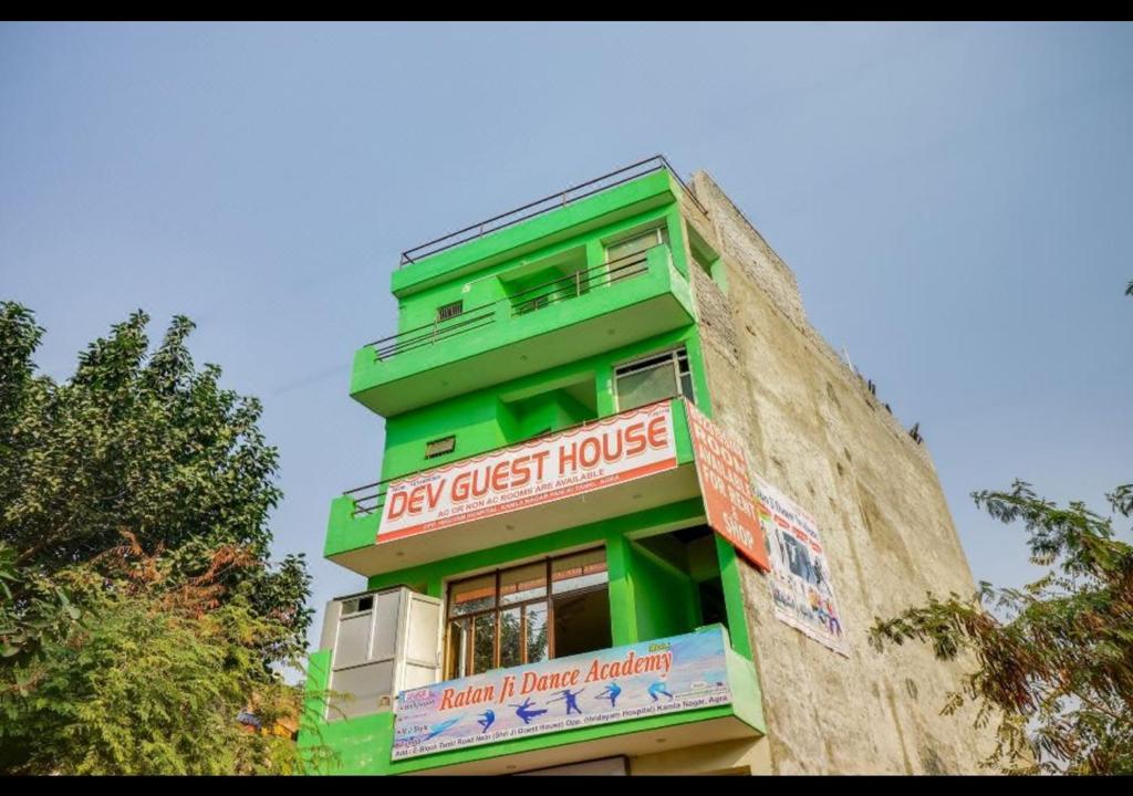 un edificio verde con un cartel en el costado en Dev Guest House By WB Inn en Agra