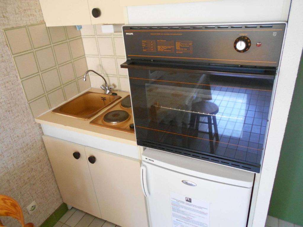 eine Küche mit Backofen und Spüle in der Unterkunft Appartement Le Grau-du-Roi, 1 pièce, 4 personnes - FR-1-250-179 in Le Grau-du-Roi