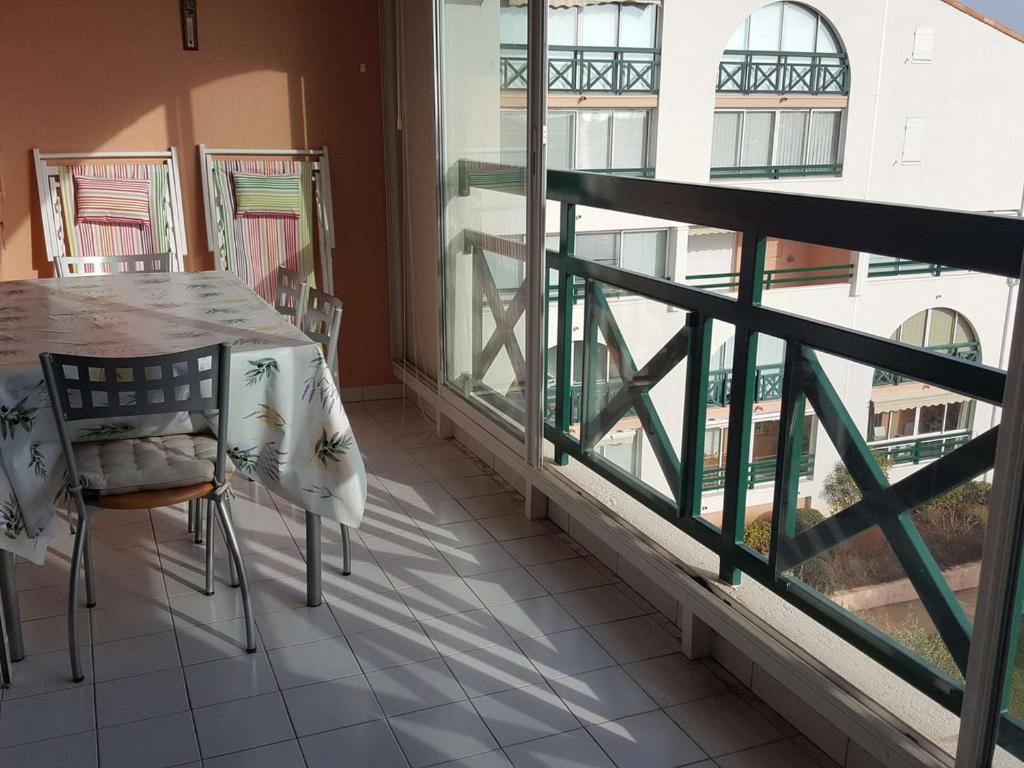 une pièce avec une table et des chaises sur un balcon dans l'établissement Appartement duplex 3 pièces avec piscine, climatisation et garage à Port Camargue - FR-1-250-192, au Grau-du-Roi