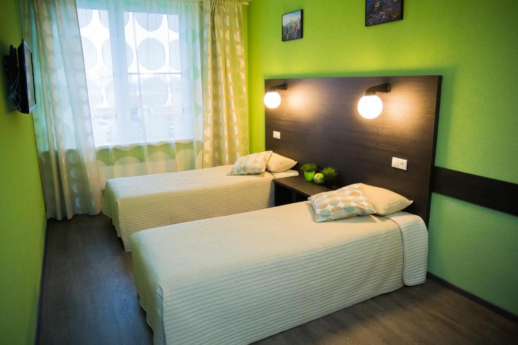 two beds in a room with green walls at Kosmos, mini-hotel in Saint Petersburg