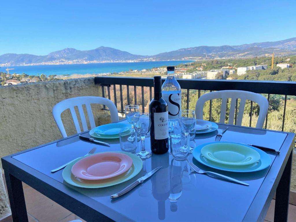 einen blauen Tisch mit einer Flasche Wein und Gläsern in der Unterkunft Appartement Porticcio, 2 pièces, 4 personnes - FR-1-61-539 in Porticcio