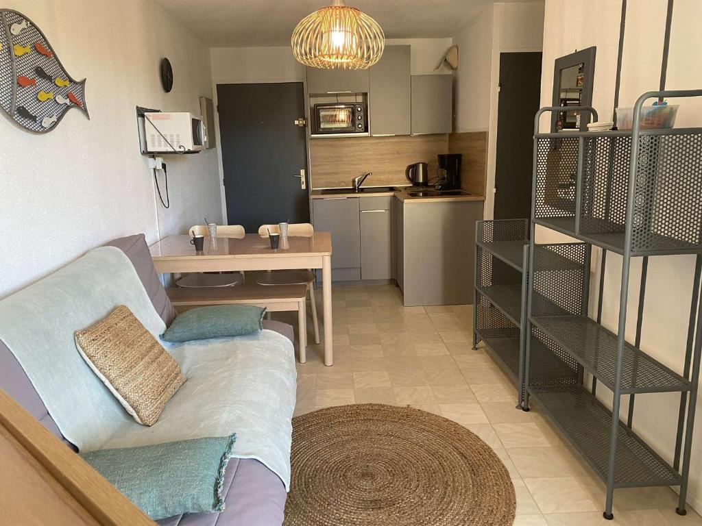 un salon avec un canapé et une cuisine dans l'établissement Appartement 2 pièces avec parking privé au Grau-du-Roi - FR-1-250-233, au Grau-du-Roi
